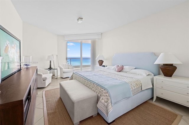 tiled bedroom with access to exterior, a water view, and expansive windows