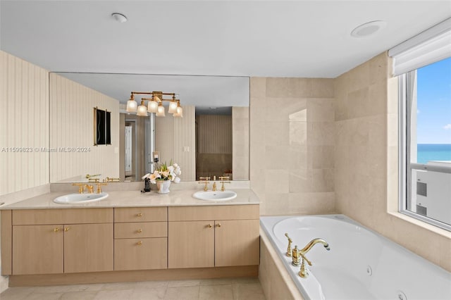 bathroom with vanity, a water view, and tiled tub