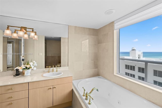 bathroom featuring vanity, a water view, and a bath