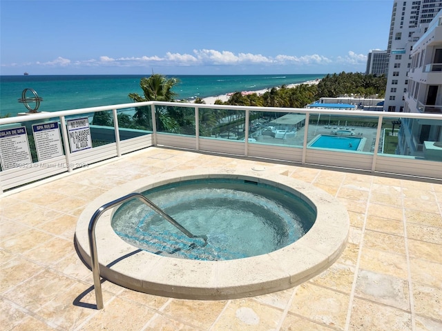 view of swimming pool featuring a water view and a hot tub