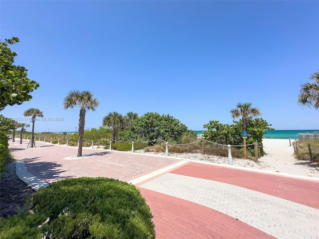 view of property's community with a water view and a view of the beach