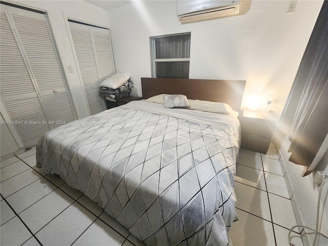 tiled bedroom with two closets and a wall mounted AC