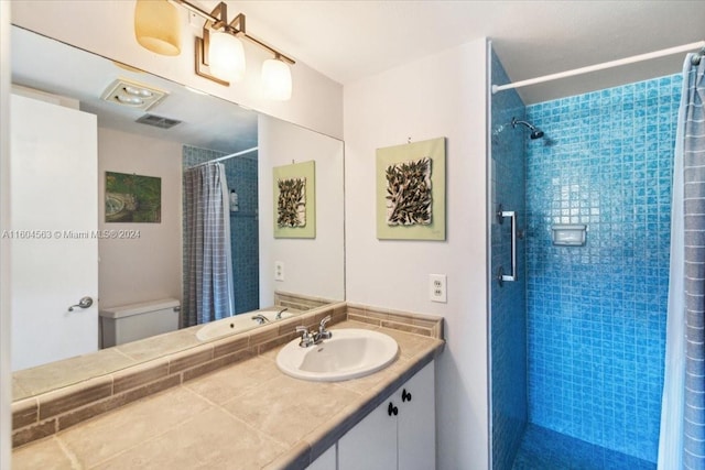 bathroom featuring large vanity, curtained shower, and toilet