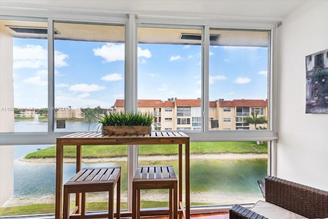 sunroom / solarium featuring a water view