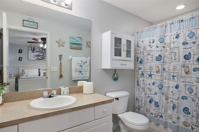 bathroom featuring vanity, toilet, curtained shower, and ceiling fan