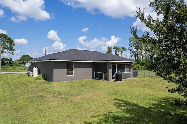 rear view of property featuring a lawn and a sunroom