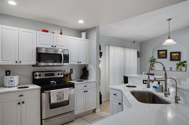 kitchen with sink, white cabinets, decorative light fixtures, and stainless steel appliances