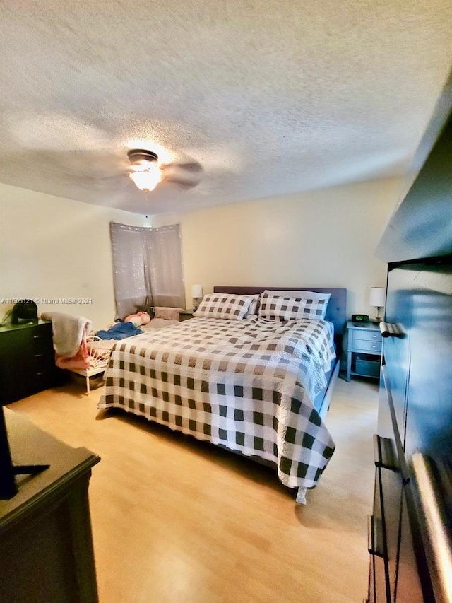 bedroom with ceiling fan and a textured ceiling