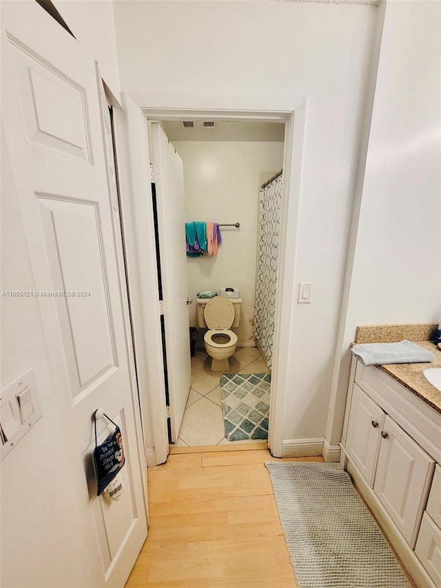 bathroom with vanity, hardwood / wood-style flooring, and toilet