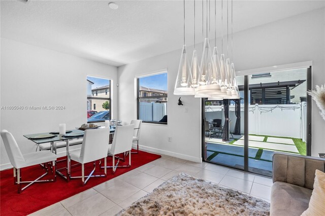 tiled dining space featuring baseboards