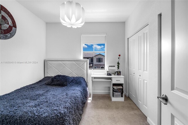 carpeted bedroom featuring a notable chandelier and a closet