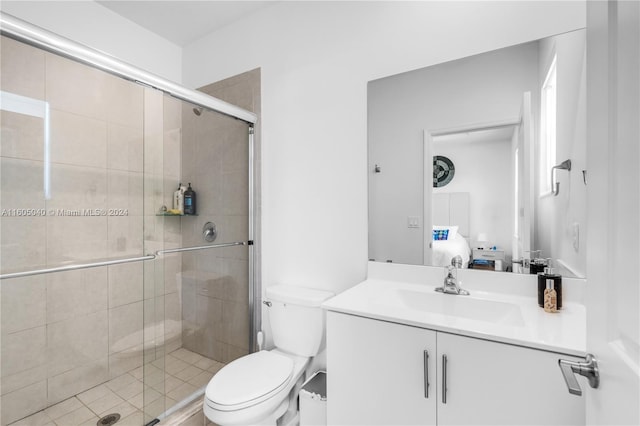 bathroom with a shower with shower door, toilet, and large vanity