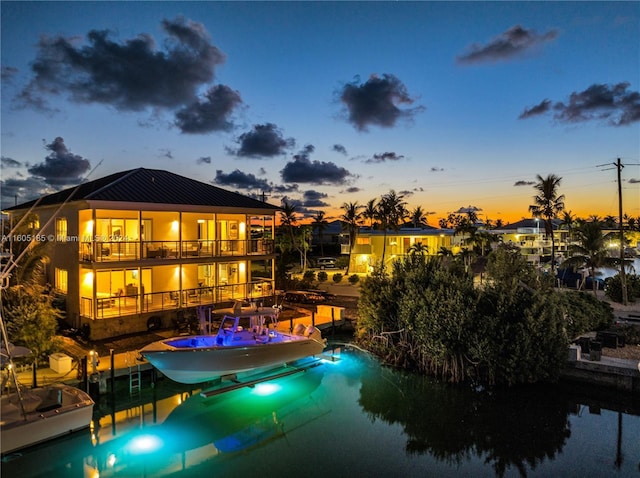 pool at dusk with a dock and a water view