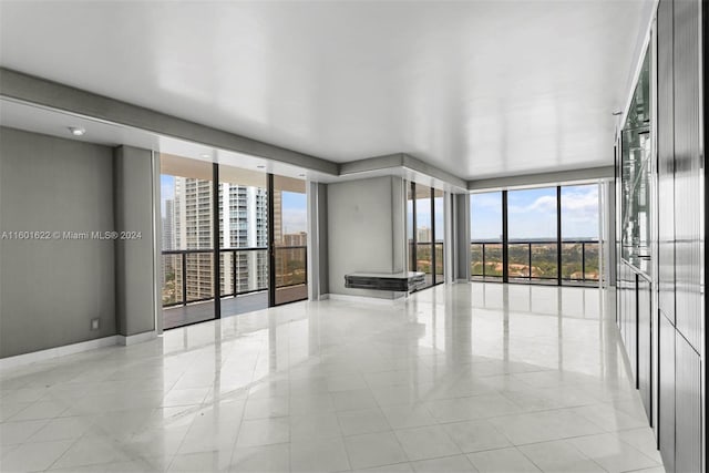 spare room with a wealth of natural light and light tile floors