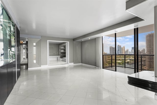 unfurnished room with light tile floors and a wall of windows