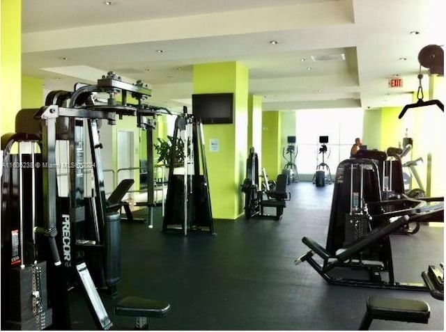 gym featuring a raised ceiling