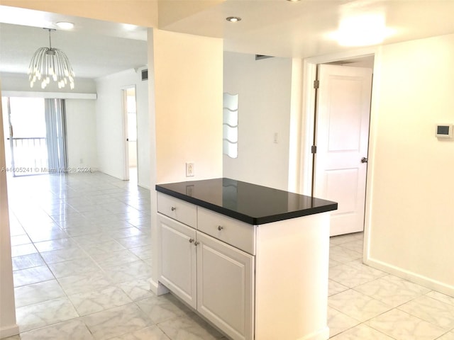 kitchen with hanging light fixtures, white cabinets, light tile patterned floors, and a chandelier