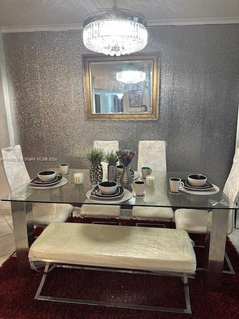 dining space featuring tile patterned flooring, ornamental molding, and a notable chandelier