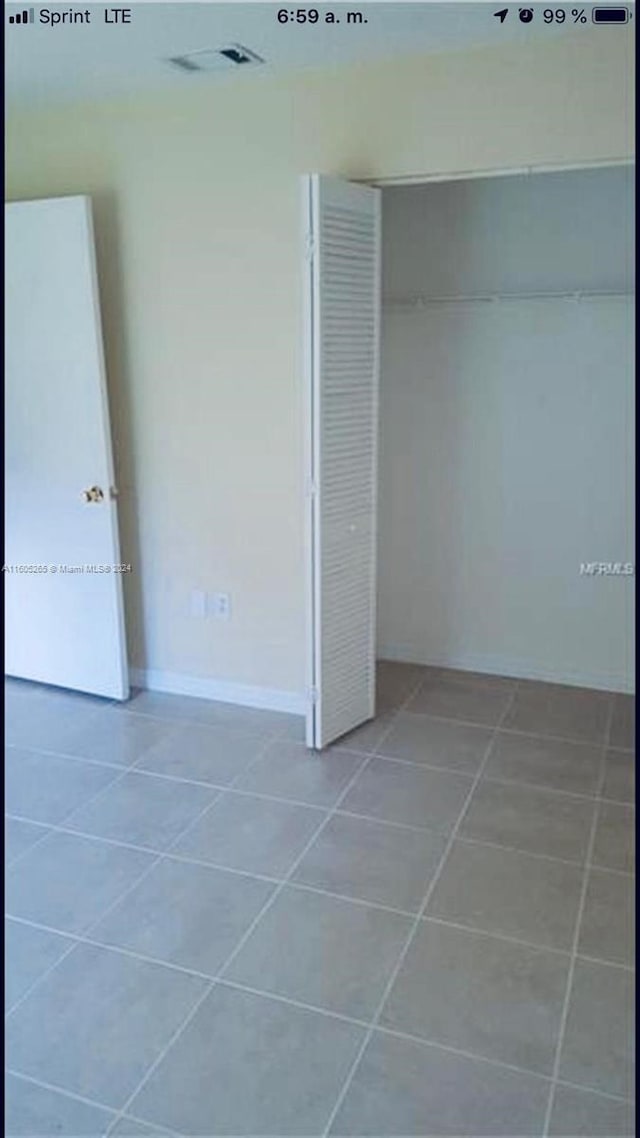 unfurnished bedroom with tile floors and a closet