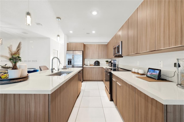 kitchen with sink, decorative light fixtures, stainless steel appliances, and a spacious island