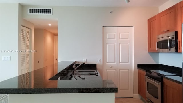 kitchen with kitchen peninsula, sink, and appliances with stainless steel finishes