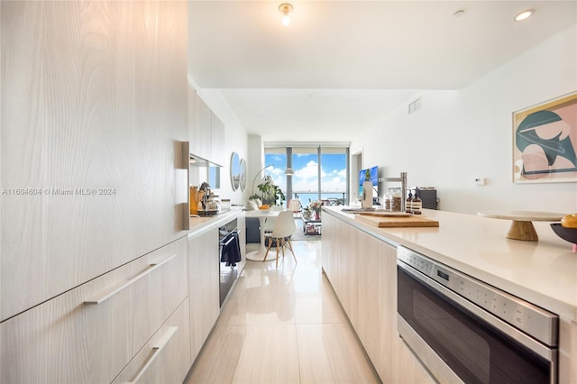 kitchen with stainless steel oven, light tile floors, and custom exhaust hood