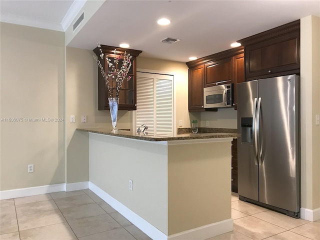 kitchen featuring dark stone counters, kitchen peninsula, ornamental molding, appliances with stainless steel finishes, and light tile floors