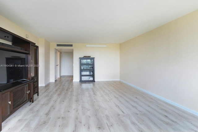 unfurnished living room with visible vents, light wood-style flooring, and baseboards