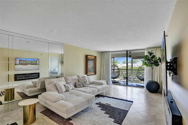 tiled living room with ceiling fan, expansive windows, and a textured ceiling