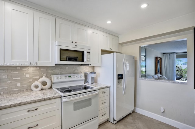 kitchen featuring white appliances, white cabinets, light stone countertops, light tile patterned floors, and tasteful backsplash