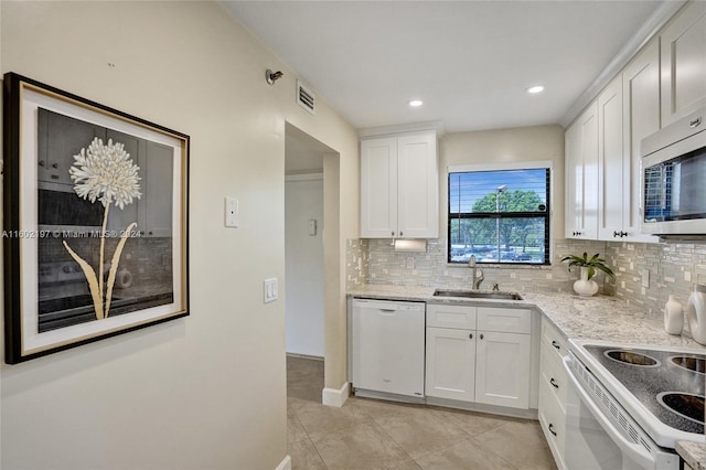 kitchen featuring white cabinets, white dishwasher, light stone countertops, and sink