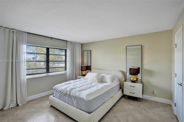 bedroom featuring light tile patterned floors and a textured ceiling