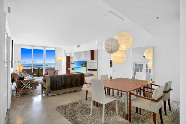 tiled dining space featuring expansive windows and a water view