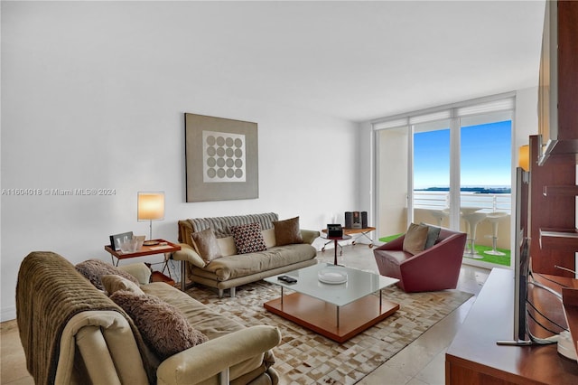 tiled living room featuring a wall of windows and a water view