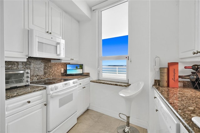 kitchen featuring white appliances, white cabinets, backsplash, and light tile floors