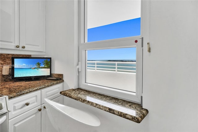 kitchen featuring white cabinets and dark stone countertops