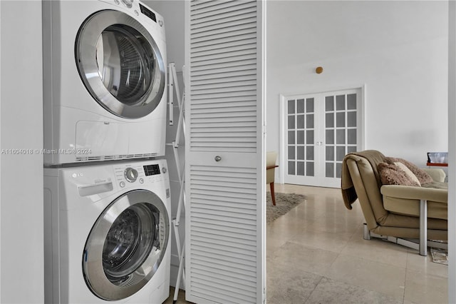 laundry room featuring light tile flooring and stacked washer and dryer