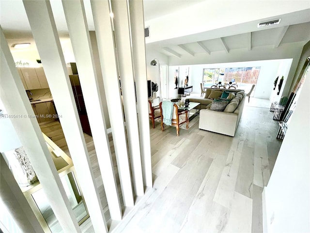 interior space featuring light hardwood / wood-style flooring and beamed ceiling