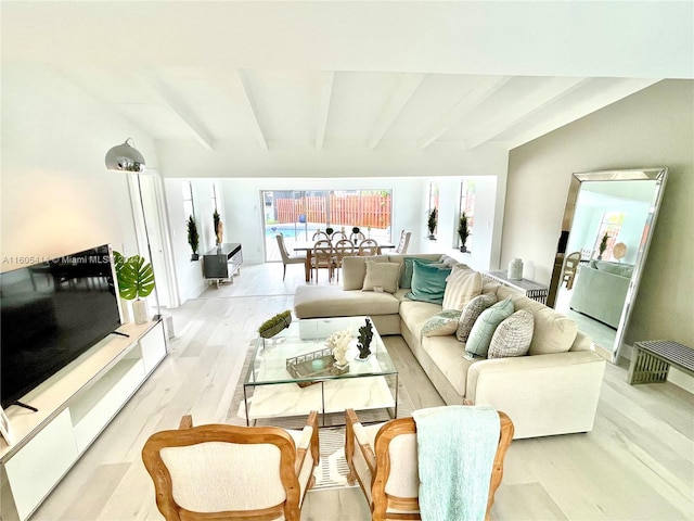 living room with beamed ceiling and light hardwood / wood-style floors