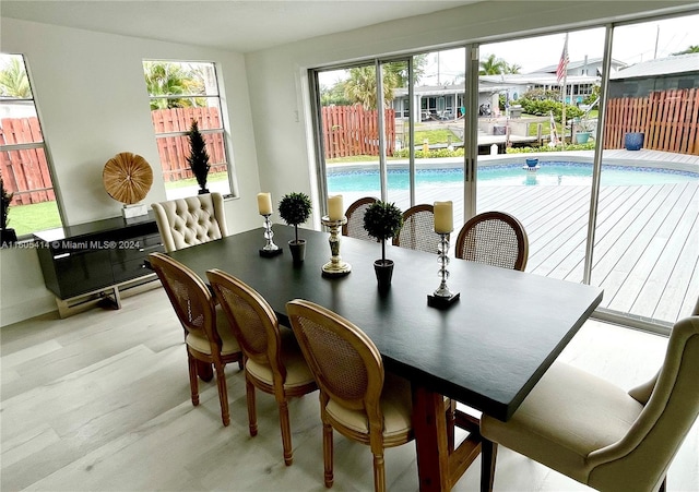 dining room with light hardwood / wood-style floors and a healthy amount of sunlight