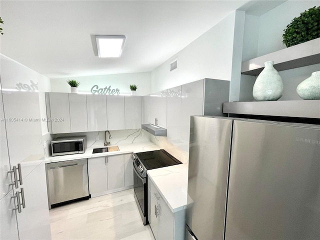 kitchen featuring white cabinetry, sink, and appliances with stainless steel finishes