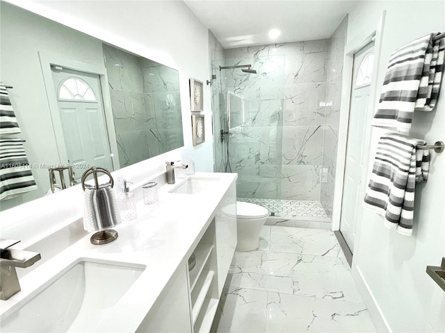 bathroom with tiled shower, vanity, and toilet