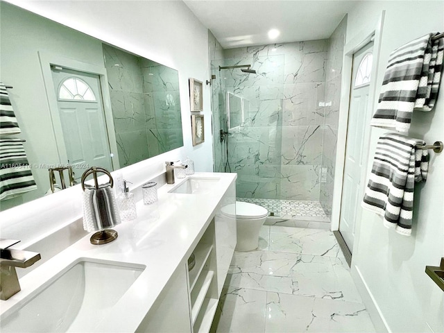 bathroom featuring a tile shower, vanity, and toilet