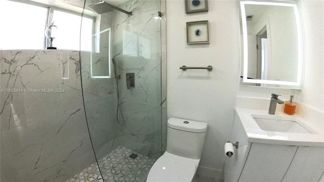 bathroom featuring vanity, toilet, and a tile shower