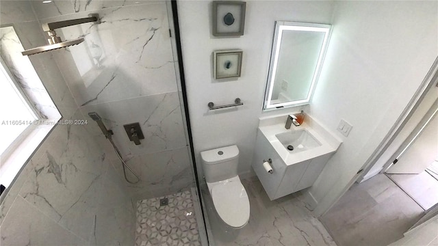 bathroom with vanity, toilet, and a tile shower