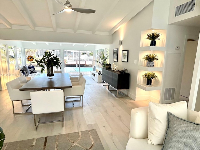 living room with beamed ceiling, plenty of natural light, ceiling fan, and light wood-type flooring