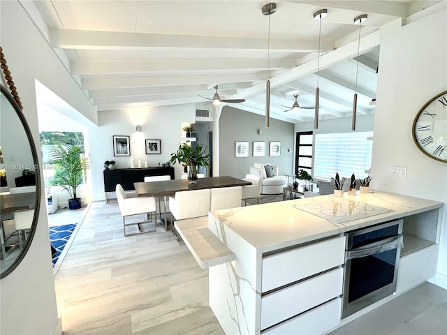 kitchen featuring decorative light fixtures, light hardwood / wood-style flooring, oven, ceiling fan, and vaulted ceiling with beams