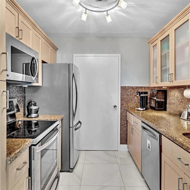 kitchen featuring light brown cabinets, backsplash, light stone countertops, a textured ceiling, and stainless steel appliances