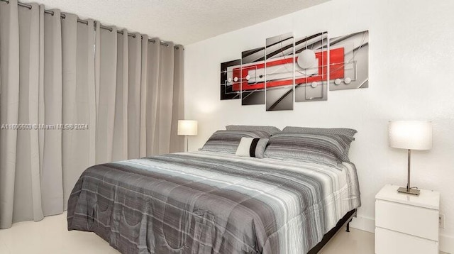 bedroom with light colored carpet and a textured ceiling