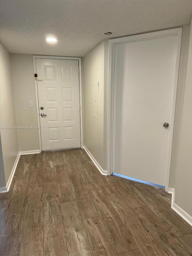 hall featuring a textured ceiling and dark hardwood / wood-style flooring